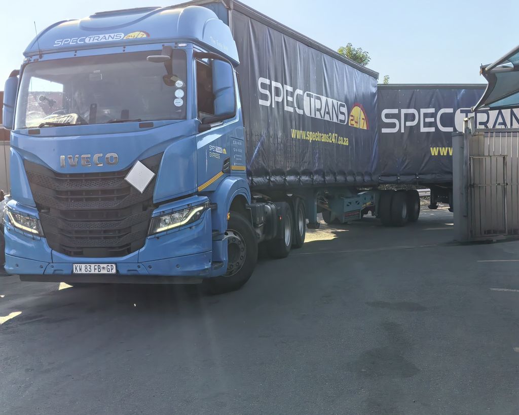 Spectrans-branded Iveco truck with a curtain-side trailer ready for distribution